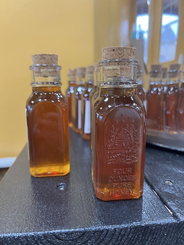 Corked honey bottles lined up in the honey house