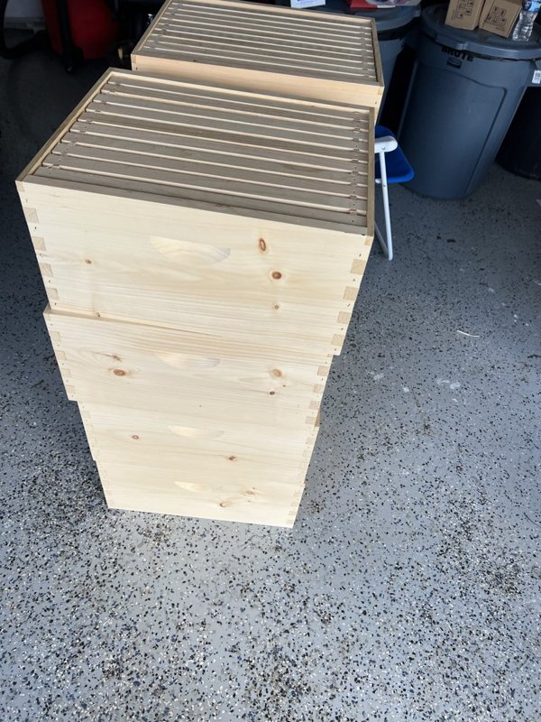 A stack of new wooden hive boxes with frames ready to go