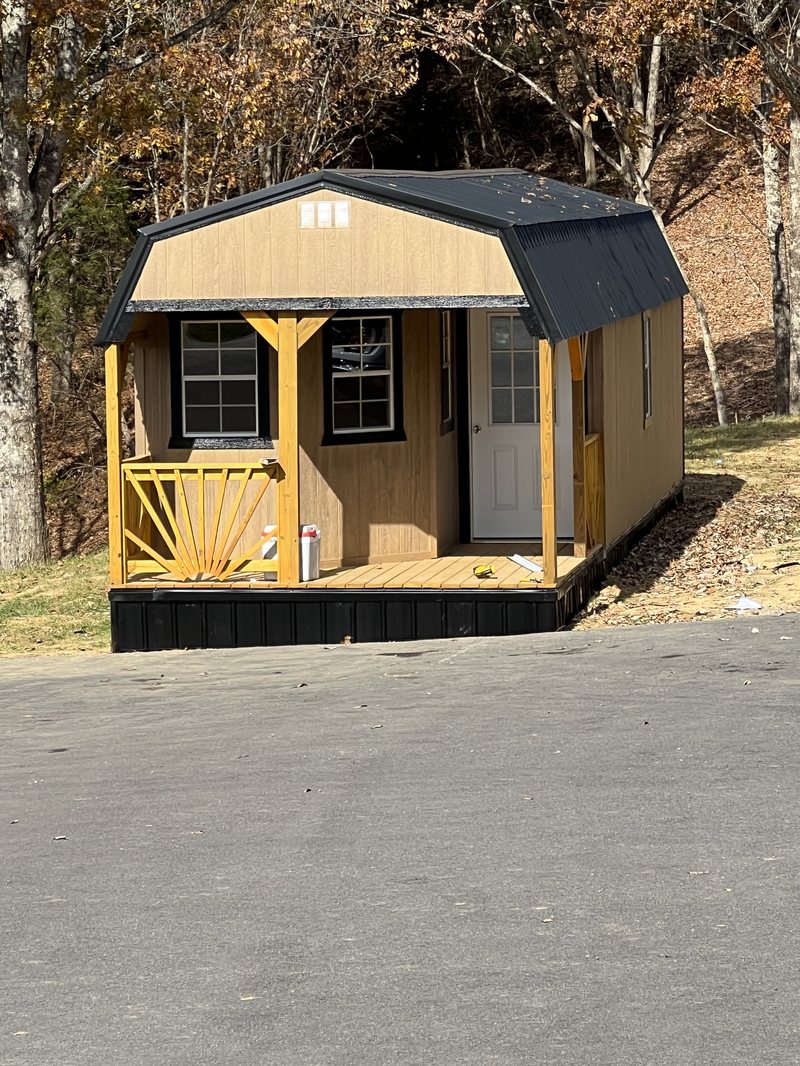 The honey house building with its covered porch and sunburst railing, just set in place