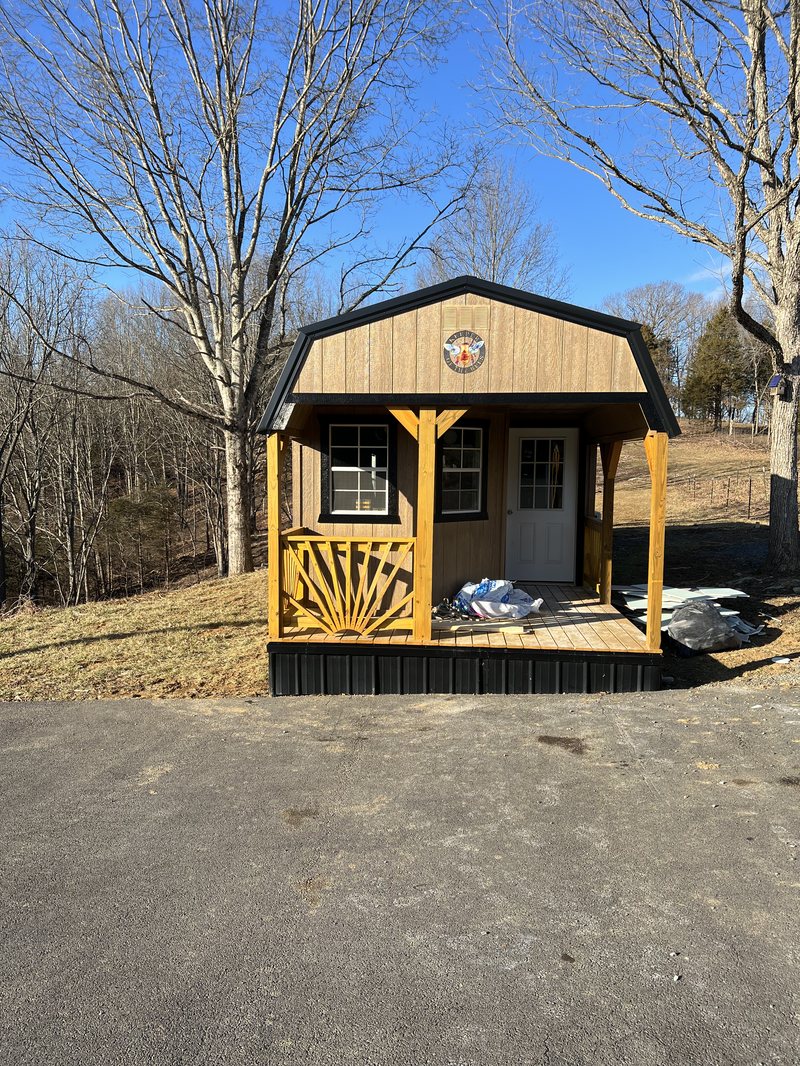 Front of the honey house with its porch, windows and bee sign