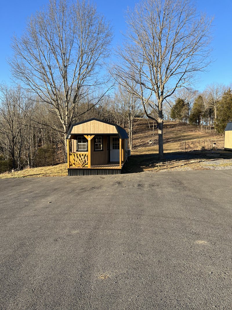 The honey house standing below bare winter trees on the hillside