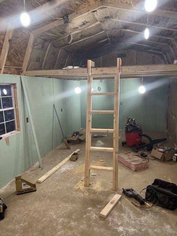 The honey house closed in with new walls, a loft and a wooden ladder