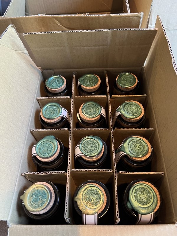 Honey jars with green wax seals packed in a box