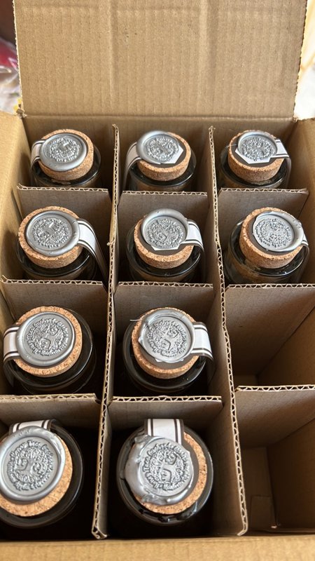 Honey jars with silver wax seals packed in a box