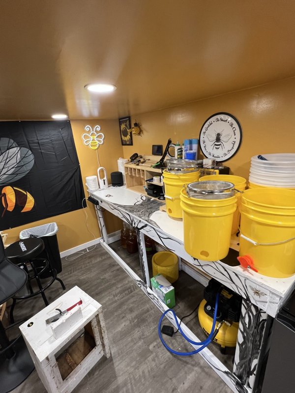 The finished honey house work counter lined with yellow honey buckets