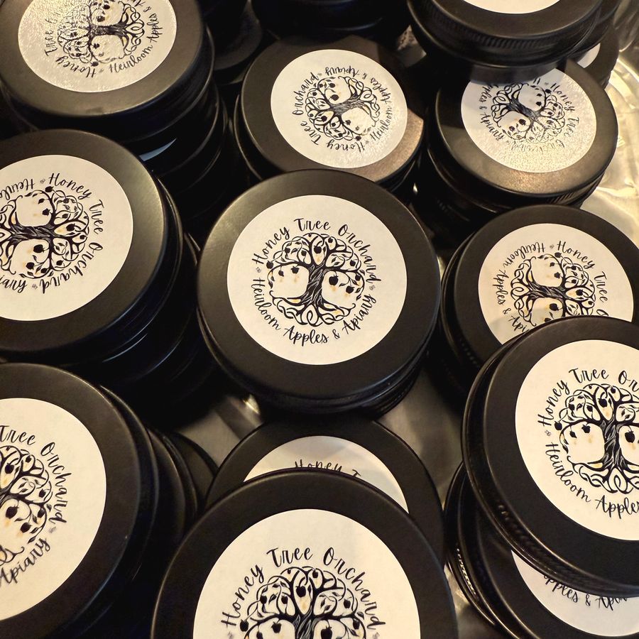 Tins with the Honey Tree Orchard tree logo on the lids